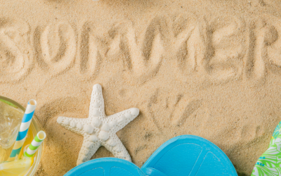 Sand with the word "SUMMER" written in it, a starfish, and colorful flip-flops, representing summer laundry tips and beach season.